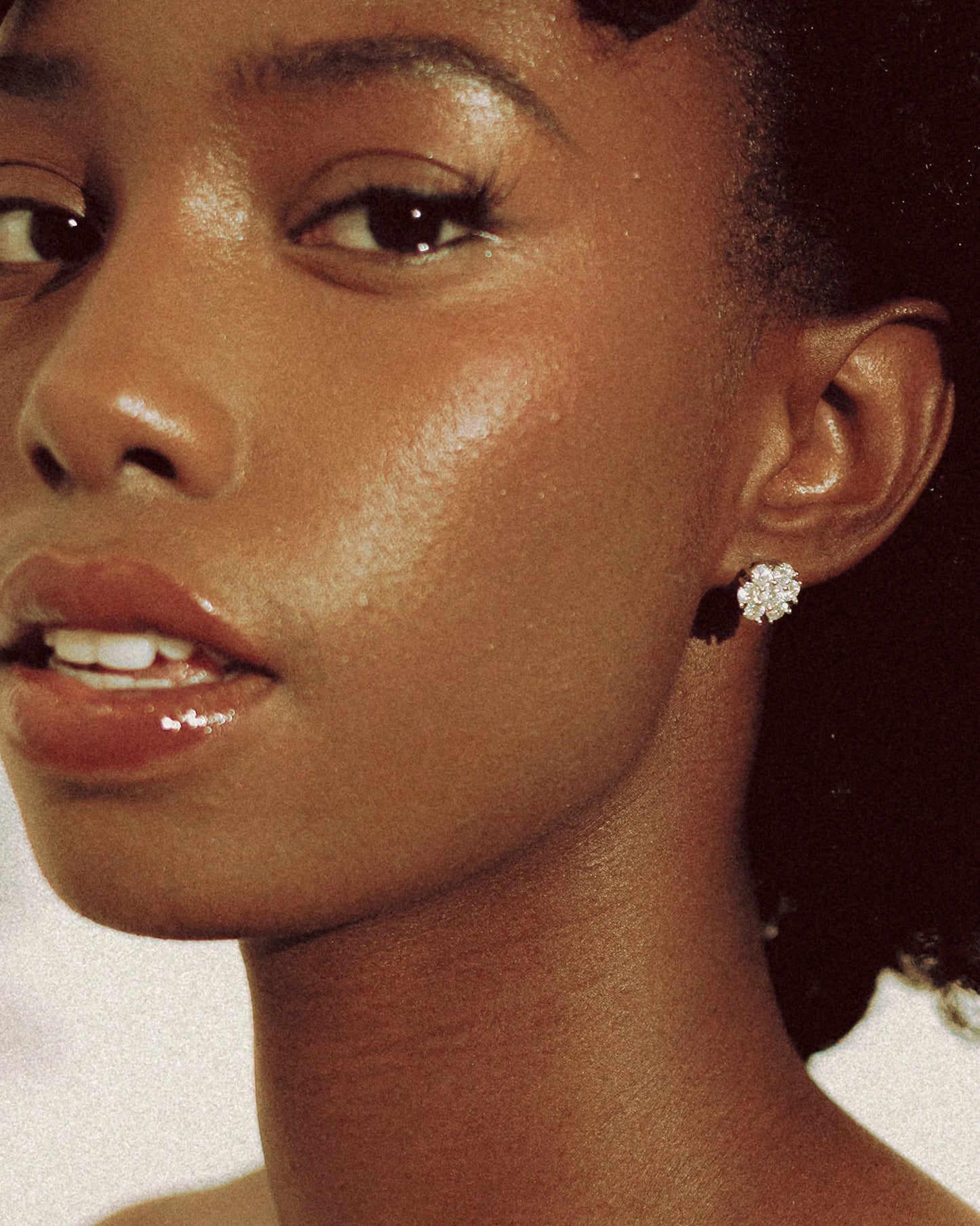 Close-up of Goldmacher Calytrix silver moissanite floral cluster earrings on the model