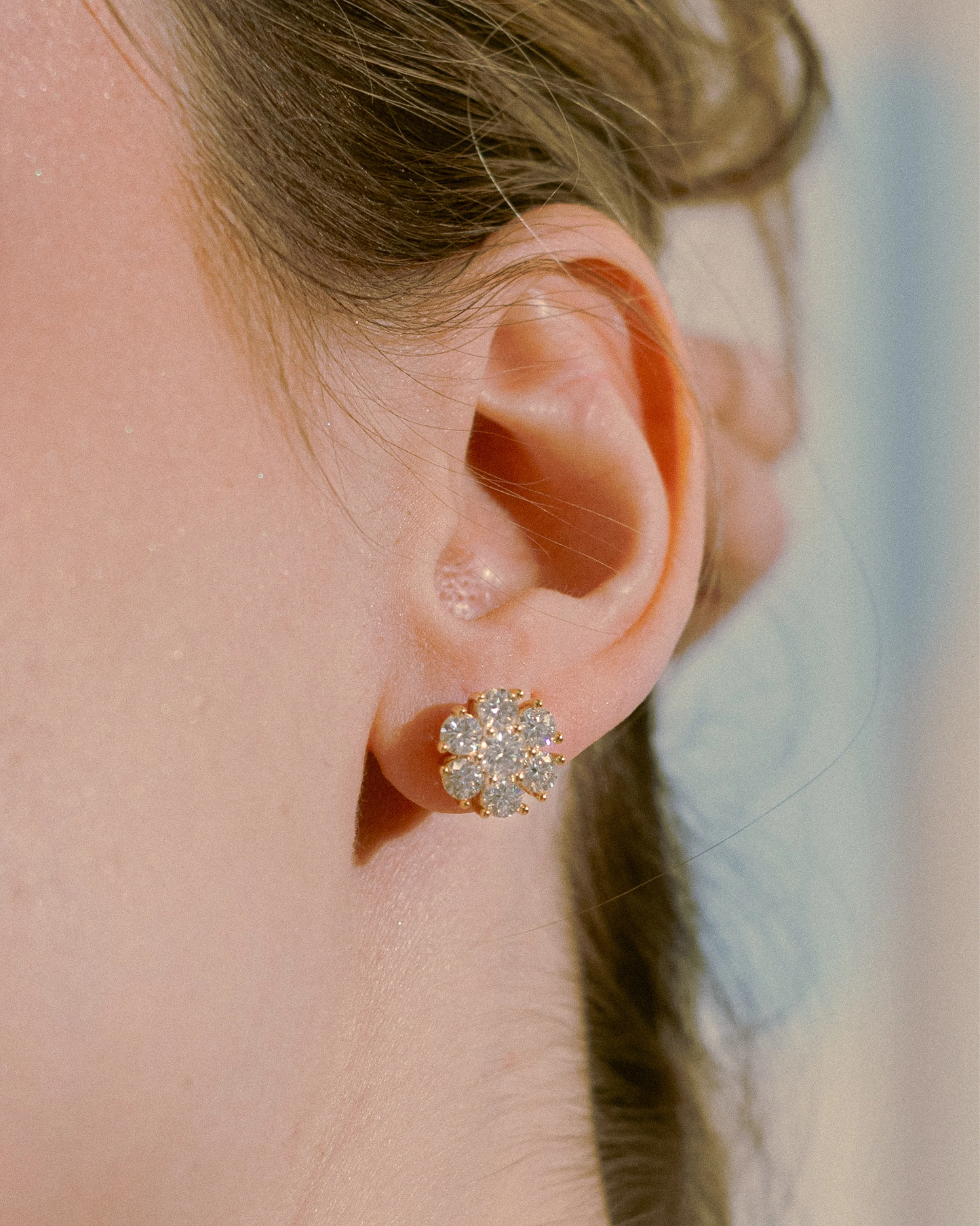 Model wearing Goldmacher Calytrix silver moissanite floral cluster earrings