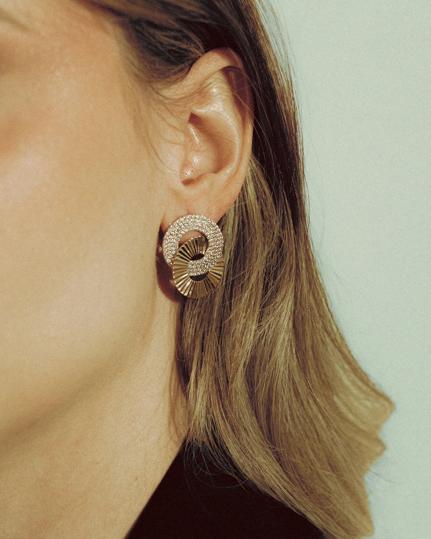 Double Deluxe Earrings by Goldmacher – Mixed gold and silver sculptural studs with zircon detail shown on model