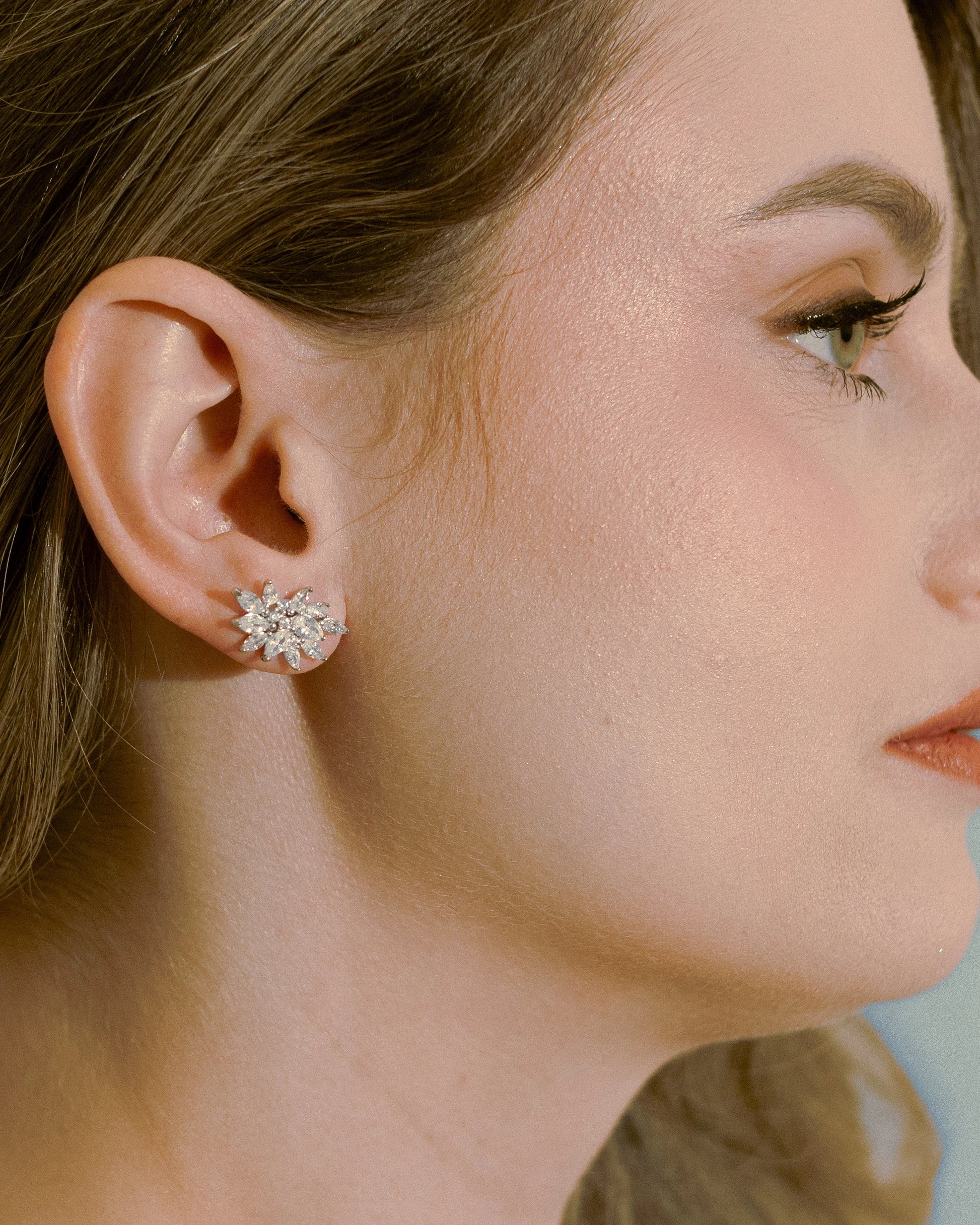 Close-up of the model wearing Goldmacher Fleur Spark earrings – floral zircon studs radiating elegance