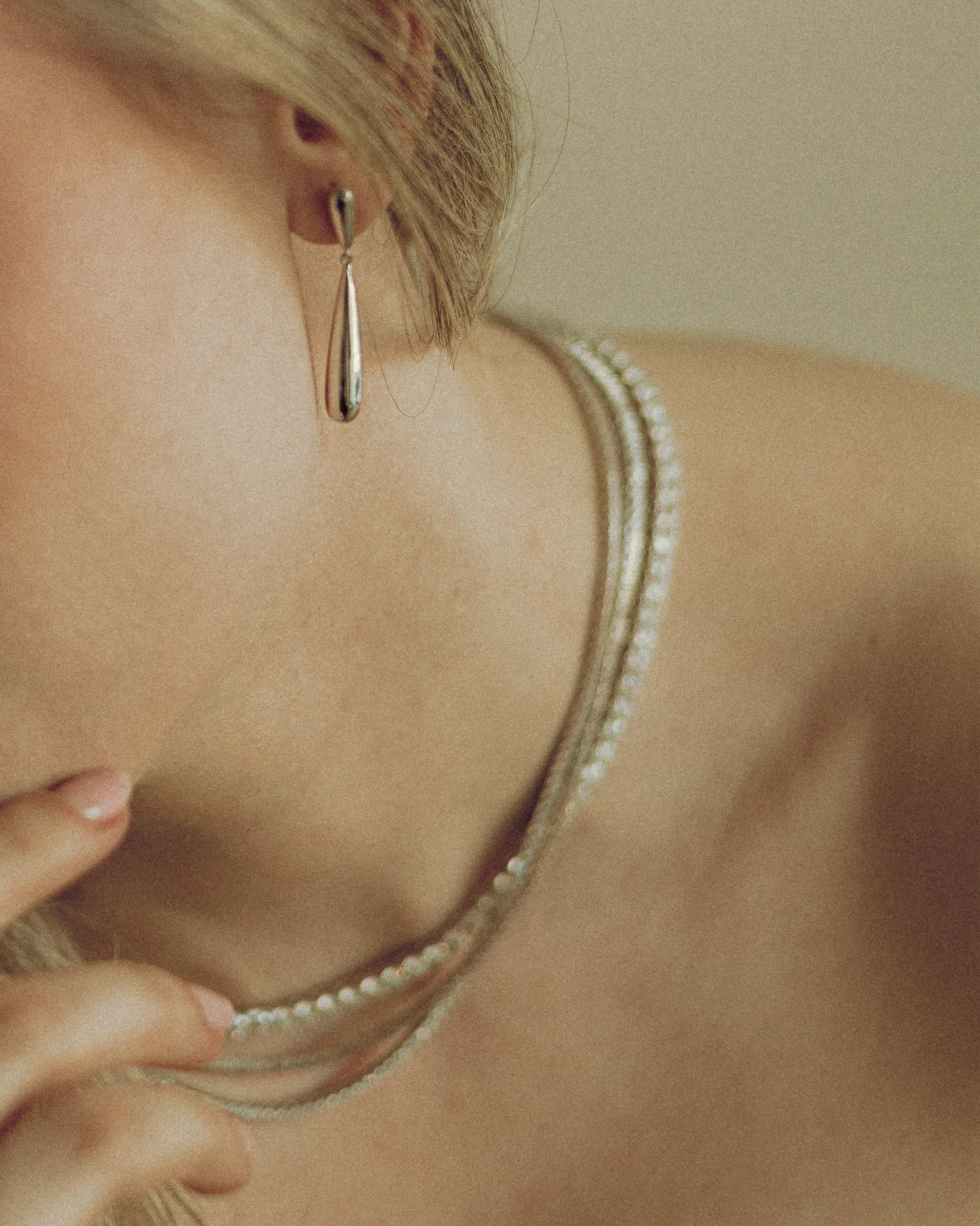 Goldmacher Long Drop Earrings – Smooth gold teardrop hoops styled on model for a refined, modern look