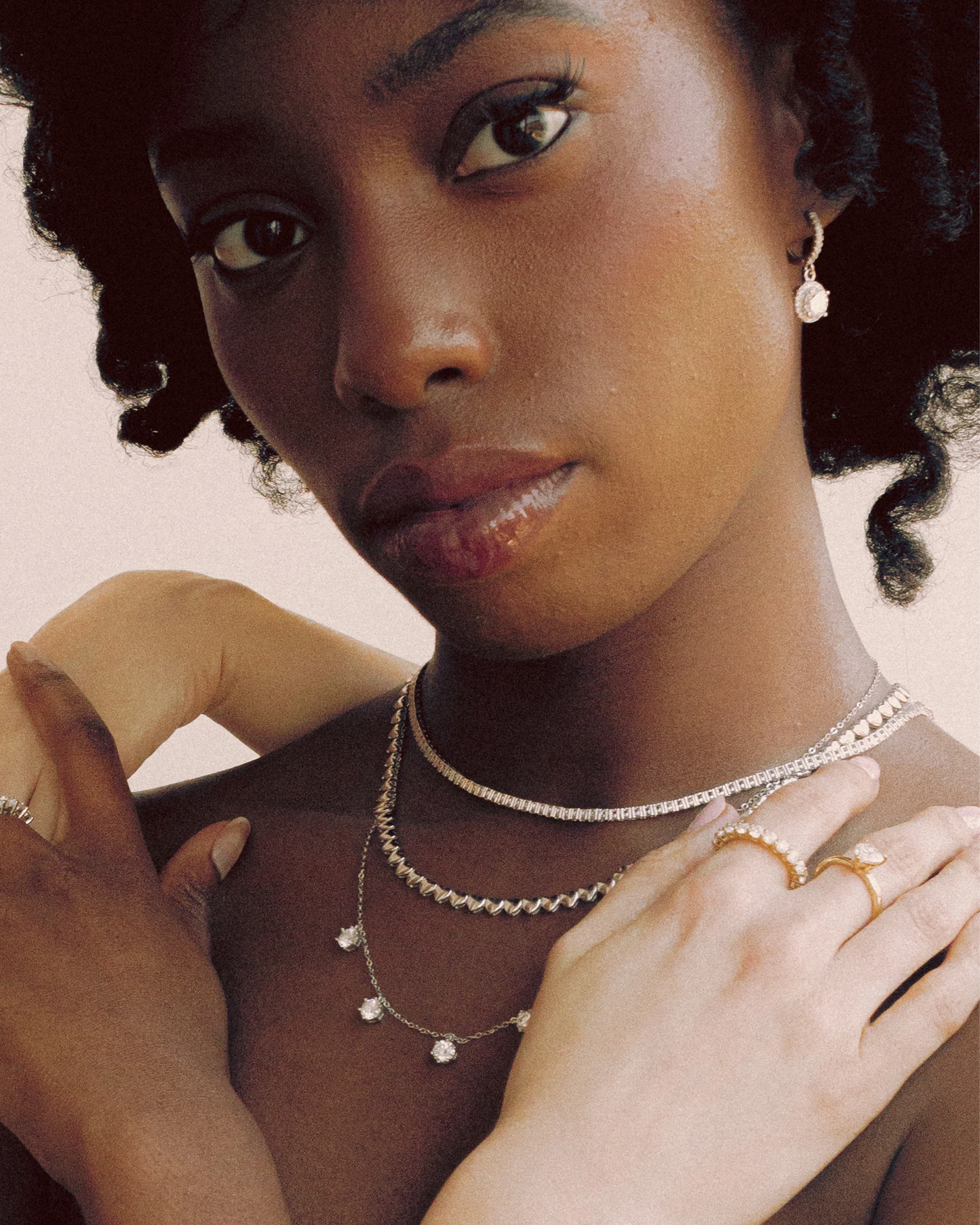 Close-up profile of the model wearing Goldmacher moissanite halo drop earrings