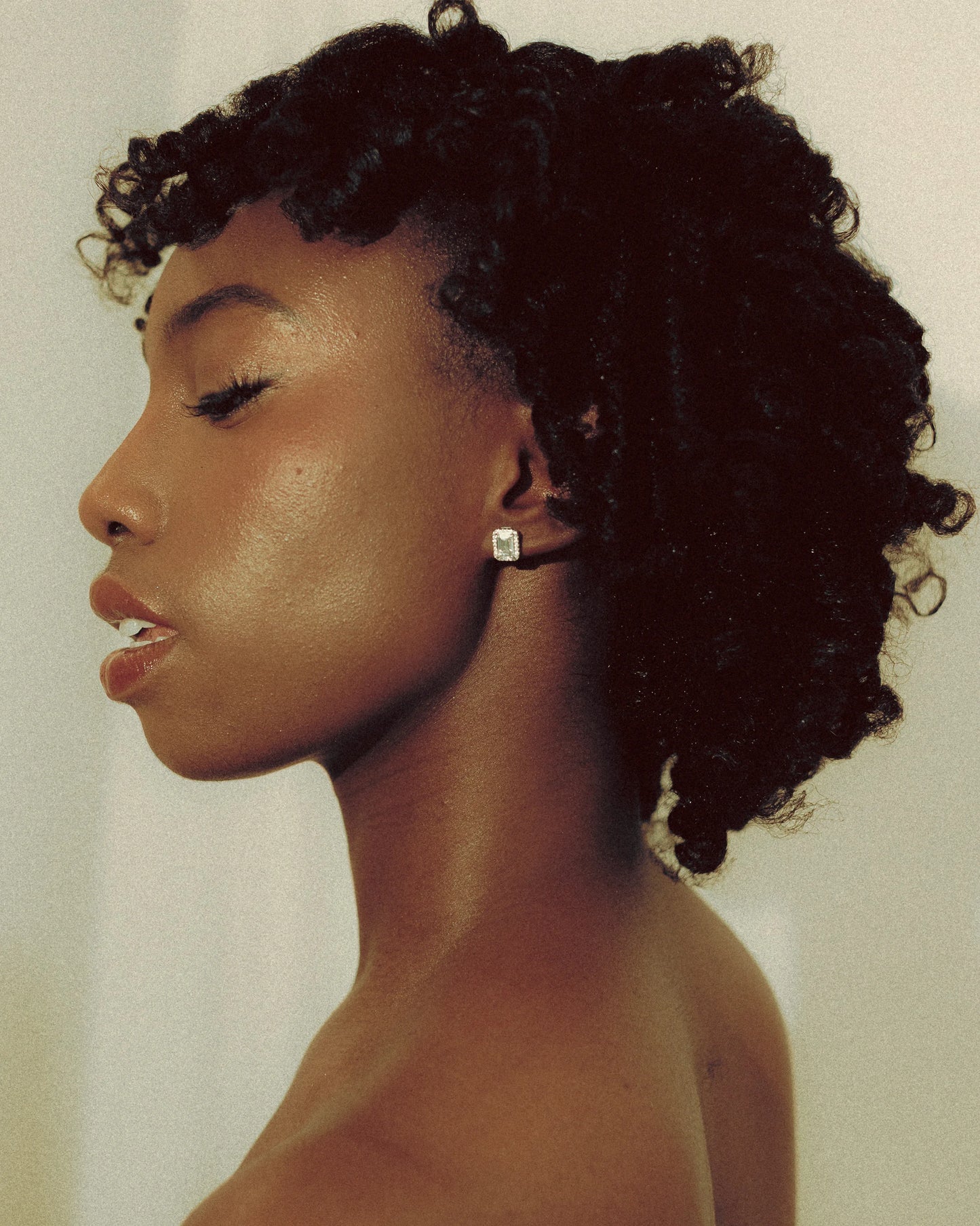 Goldmacher moissanite halo stud earrings styled on model with a minimal, layered look