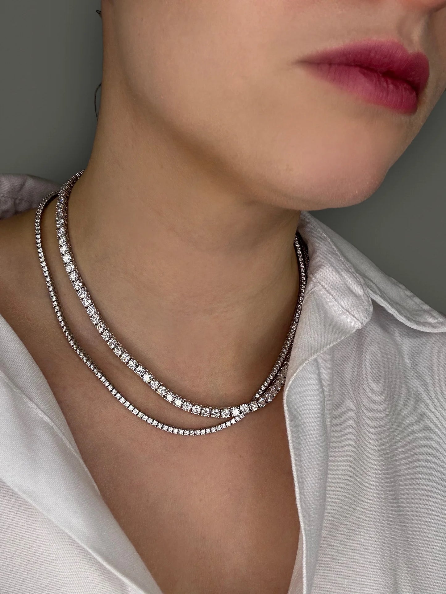 Model wearing Goldmacher moissanite tennis chain, halo stud earrings, and an eternity ring