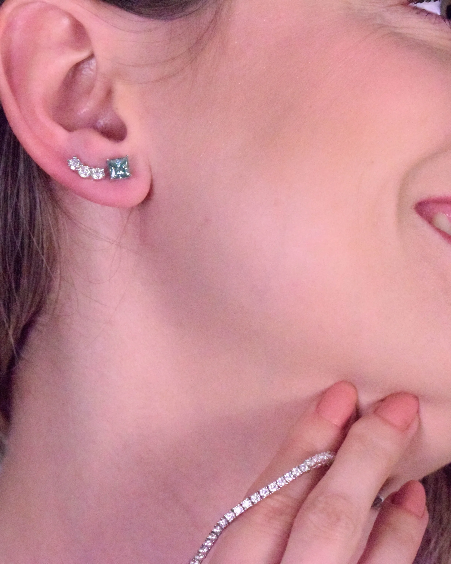 Lifestyle image of a model showcasing Goldmacher Orio 925 silver moissanite ear climber earrings
