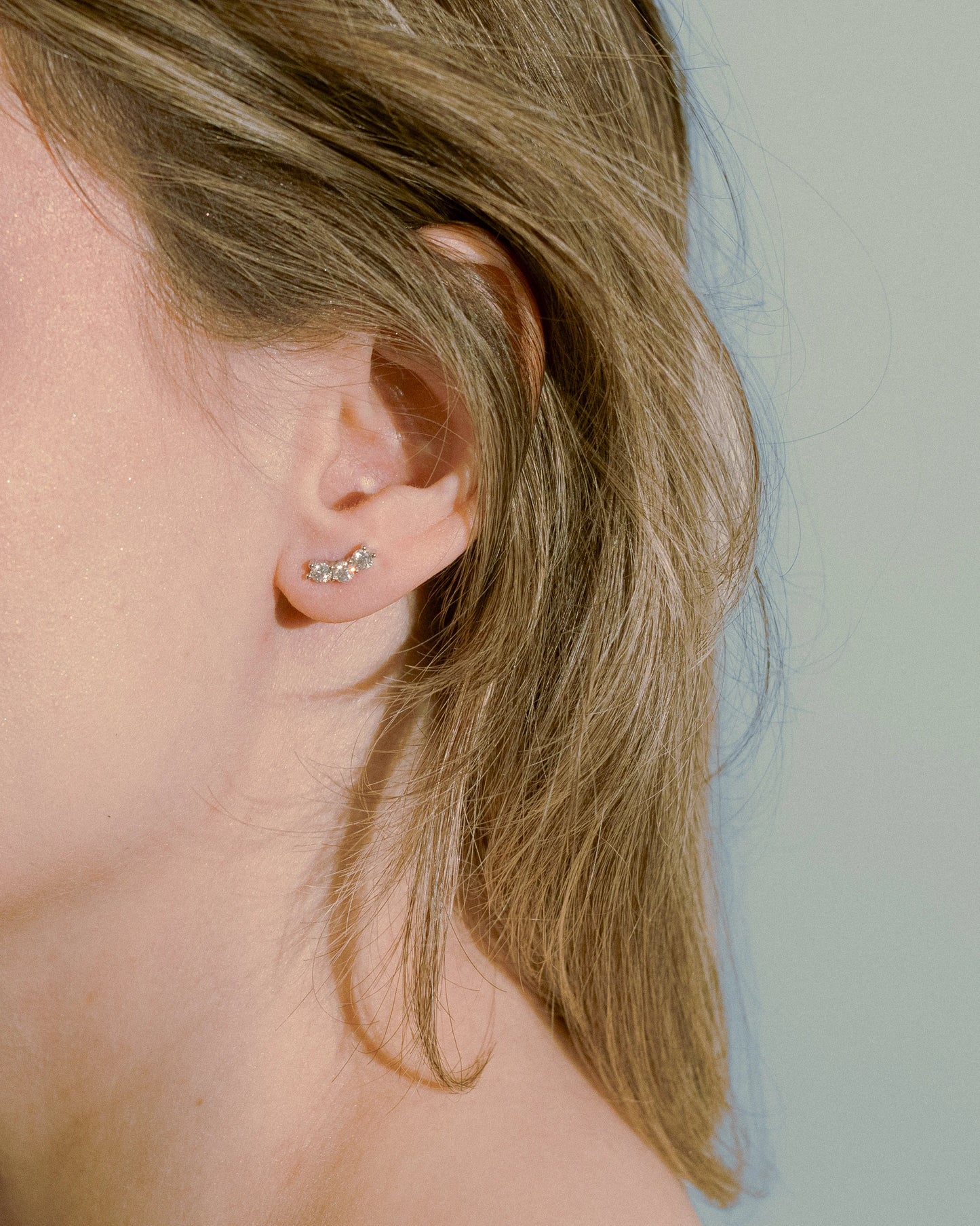Model wearing Goldmacher Orio 925 silver curved moissanite ear climber earrings