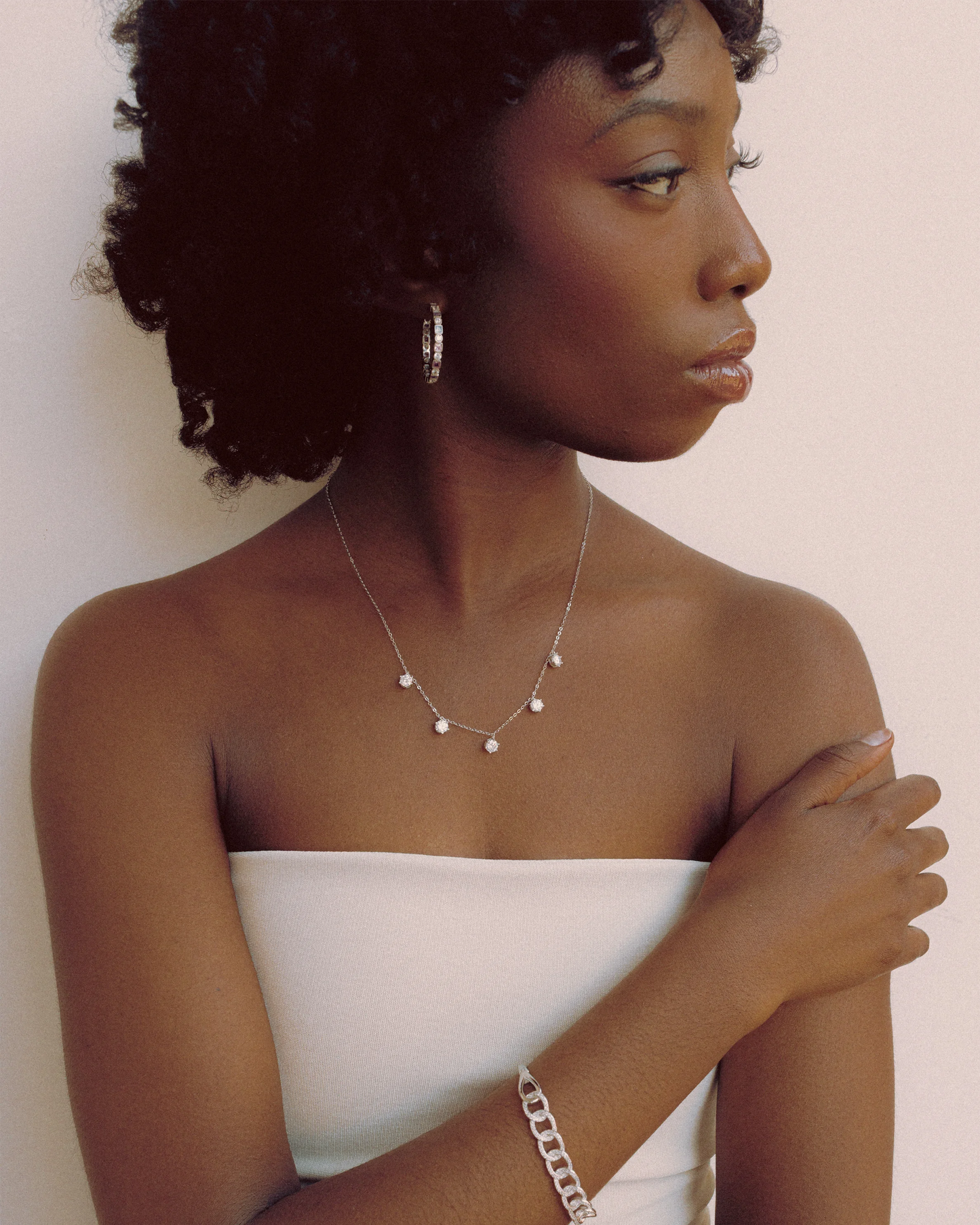 Goldmacher Prism Loop Earrings – Model styled with silver rainbow hoop earrings featuring alternating zircon cuts
