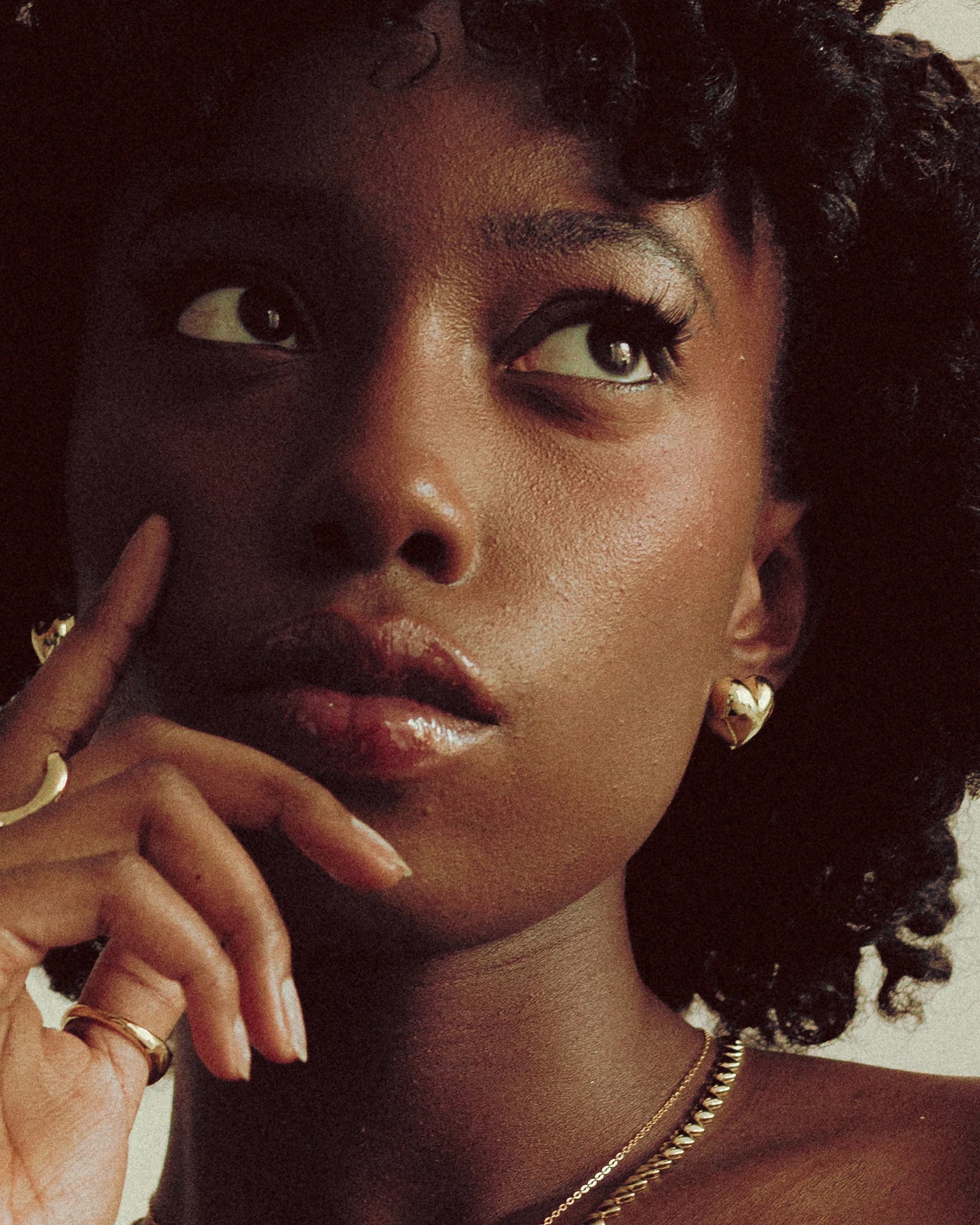 Goldmacher Puffy Heart Earrings – 18k gold-plated 925 silver heart studs worn by model in close-up view