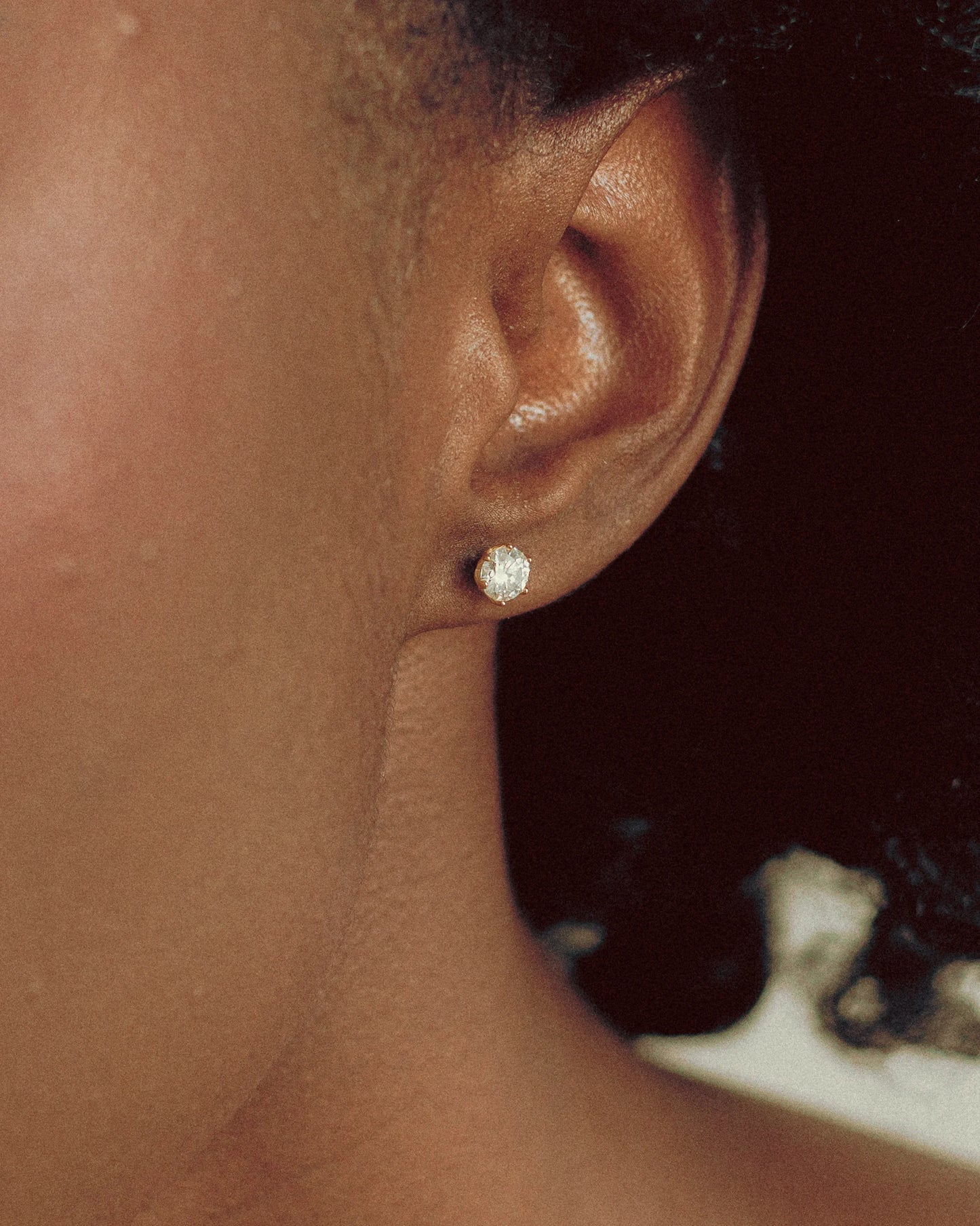Close-up of Goldmacher Zenith moissanite stud earrings with secure screw-back closure and classic six-prong setting