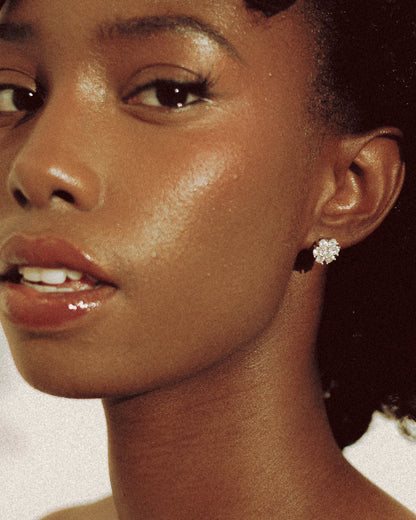 Close-up of Goldmacher Calytrix silver moissanite floral cluster earrings on the model