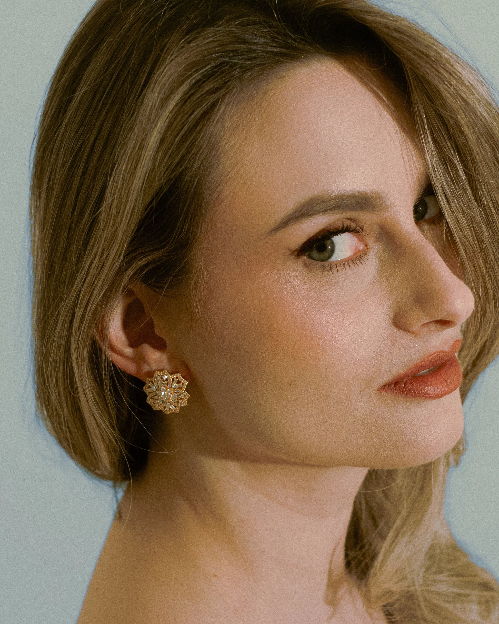 Lifestyle shot of the model blending Goldmacher moissanite floral earrings