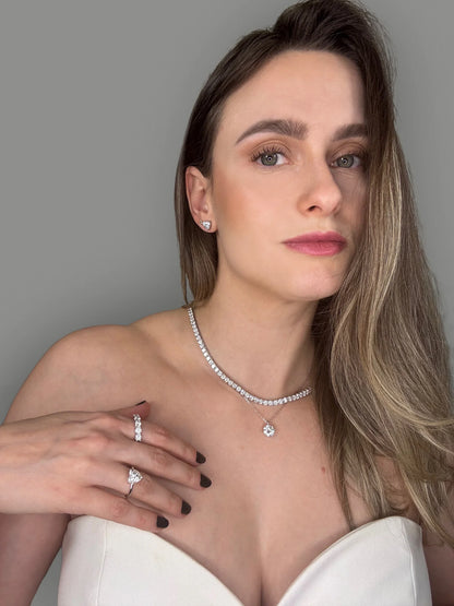 Model wearing Goldmacher moissanite tennis necklace and heart-shaped solitaire stud earrings