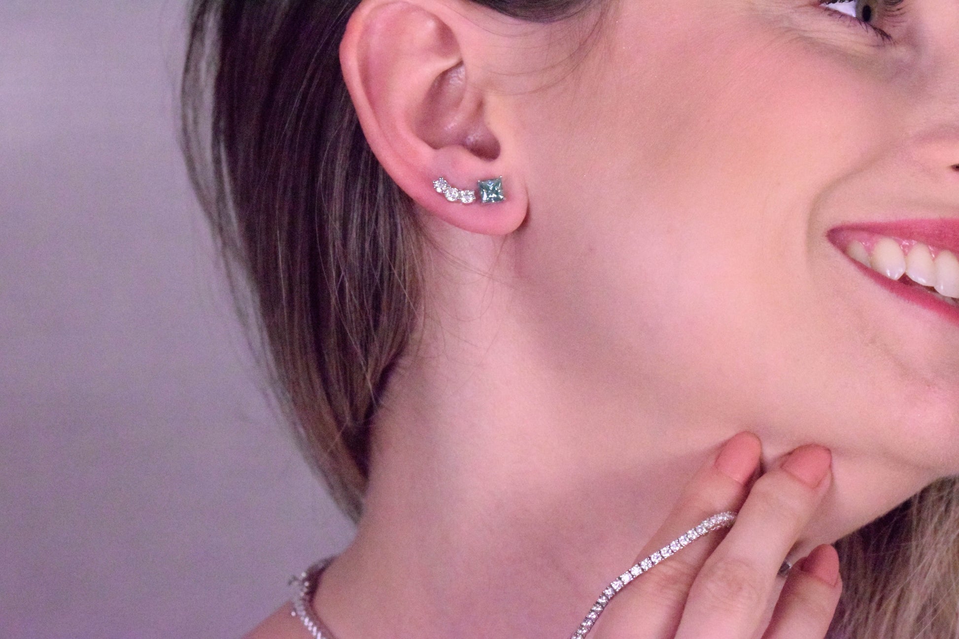 Lifestyle image of a model showcasing Goldmacher Orio 925 silver moissanite ear climber earrings