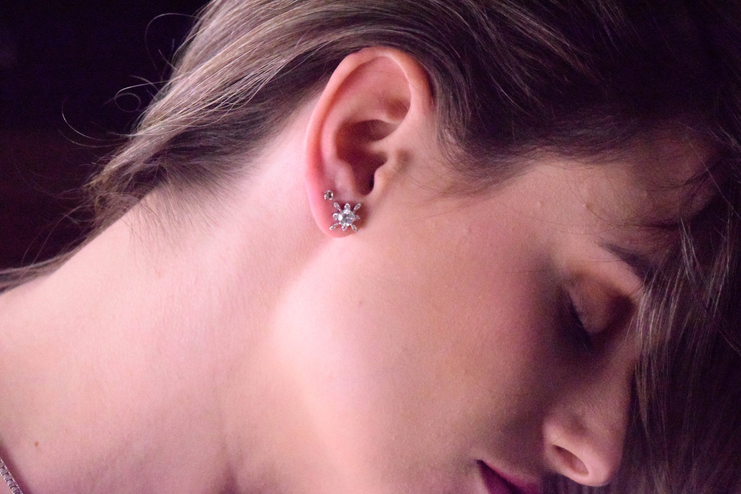 Model wearing Goldmacher Vega 925 silver star-shaped moissanite stud earrings